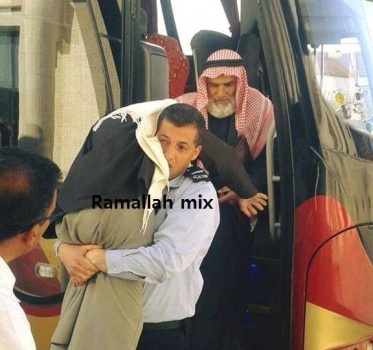 صورة شرطي فلسطيني يحمل مسناً تثير مشاعر نشطاء عبر"الفيسبوك" ..ودعوات لتكريمه!!