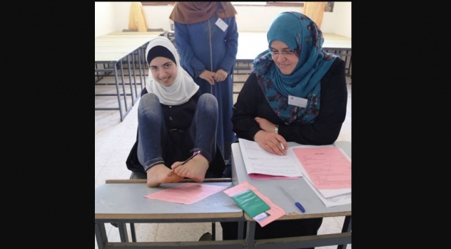 صور .. الطالبة آية "بدون يدين" تتقدم لامتحانات التوجيهي بقدميها !